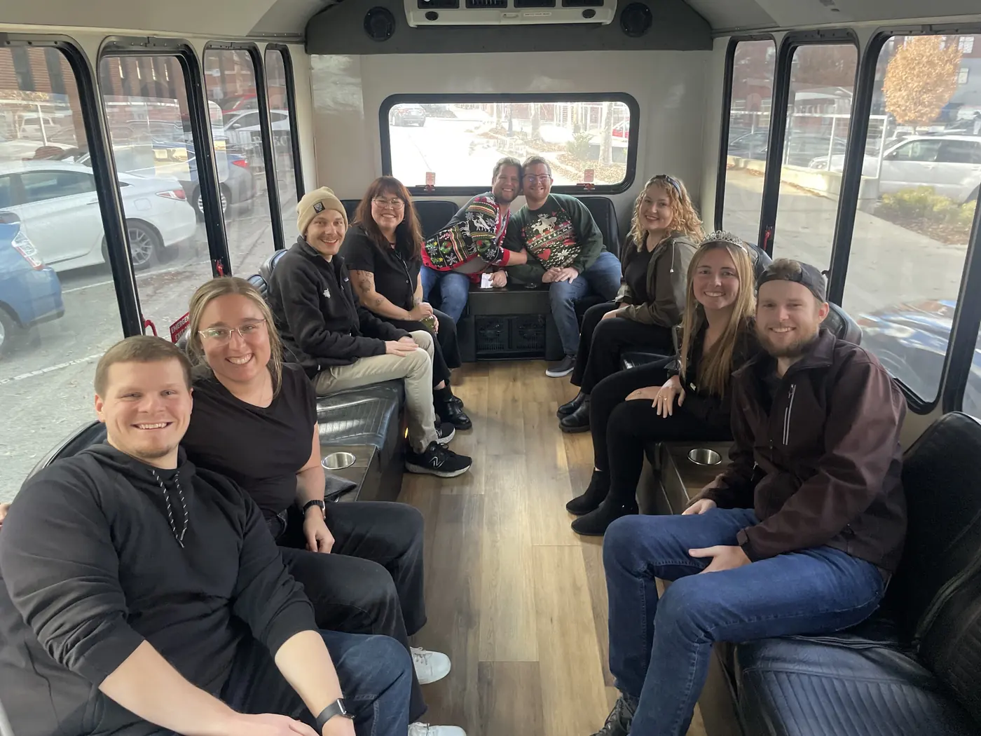 Friends in ugly Christmas sweaters on board a Barley Bus