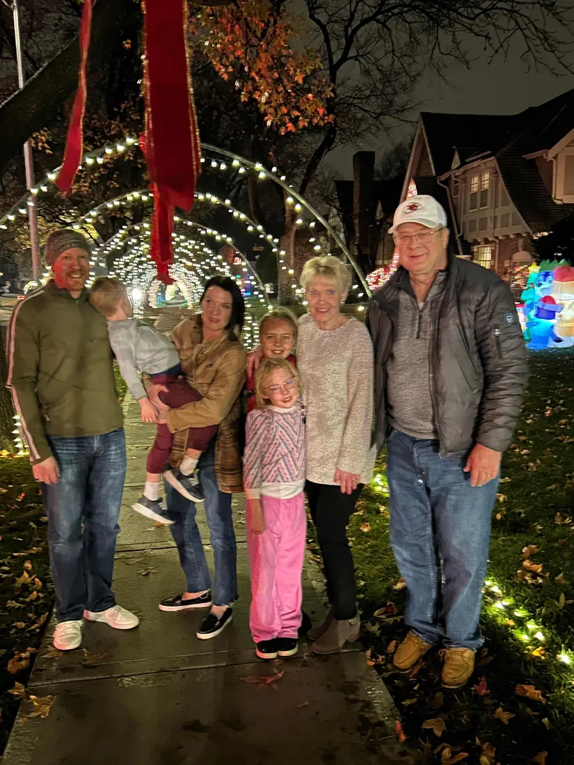 A family under a tunnel of lighted arches