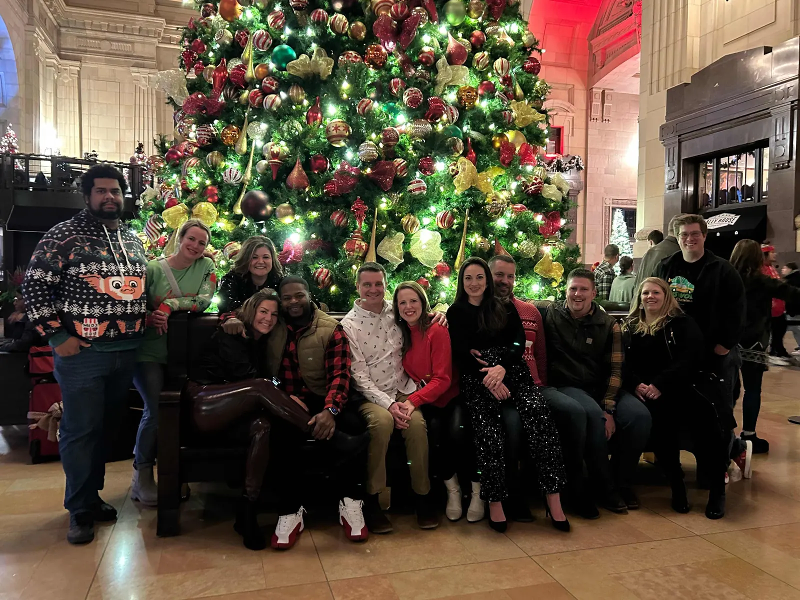 A holiday tour group in front of the Union Station Christmas tree